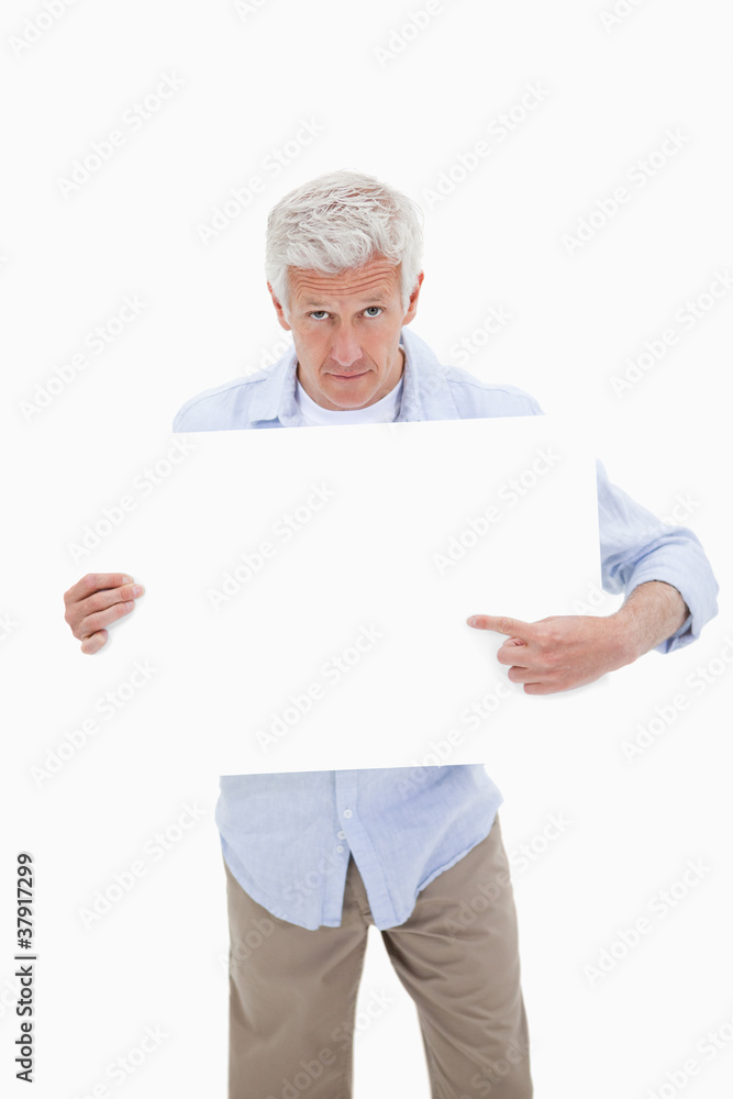 Portrait of a mature man pointing at a blank board Portrait of a mature man pointing at a blank board