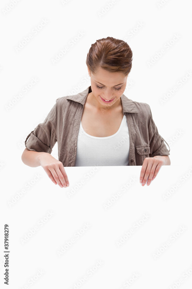 Woman looking down at blank signboard Woman looking down at blank signboard