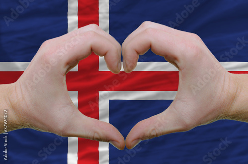 Heart and love gesture showed by hands over flag of iceland back photo