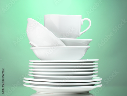 Clean plates and cup on green background