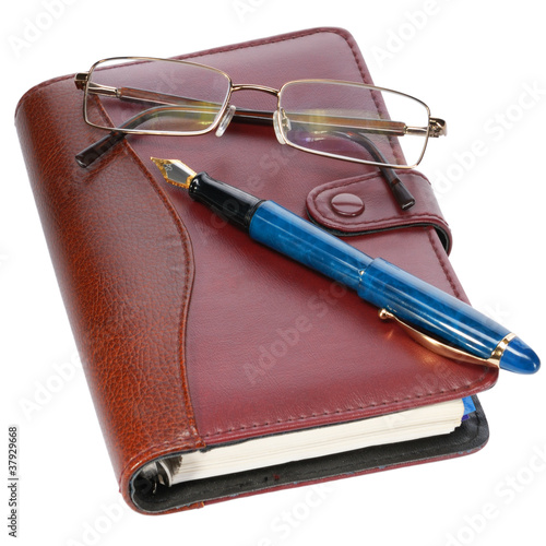 Fountain pen and diary on white background