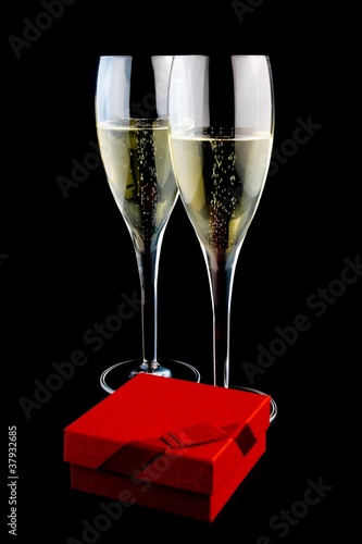 two glass with champagne near a gift