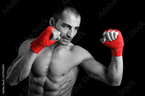 Young Boxer fighter over black background