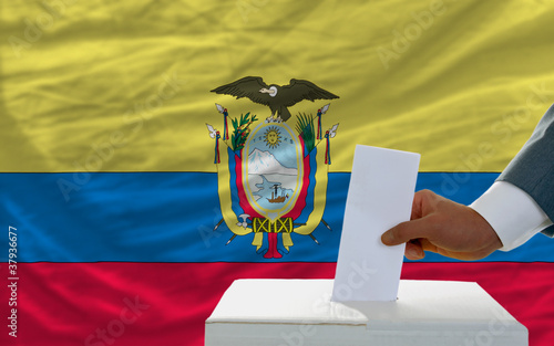 man voting on elections in ecuador in front of flag photo