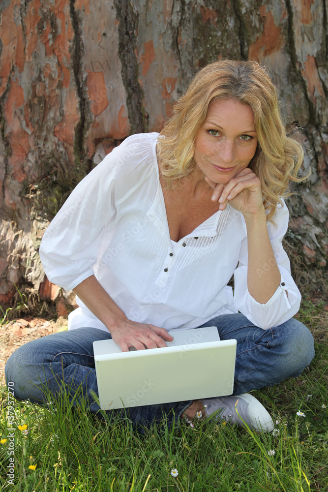 woman sitting against a tree woman sitting against a tree