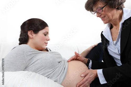 Valokuva Doctor feeling a woman's pregnant stomach