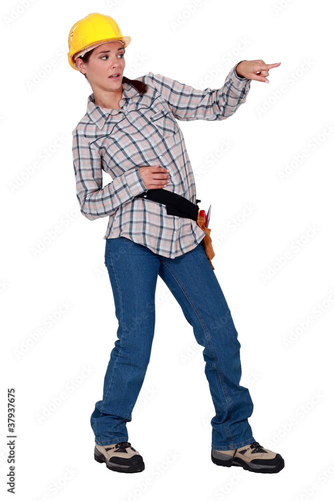 A disgusted female construction worker pointing at something. A disgusted female construction worker pointing at something.