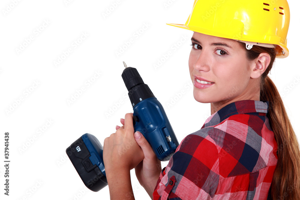 A female construction worker holding a drill. A female construction worker holding a drill.