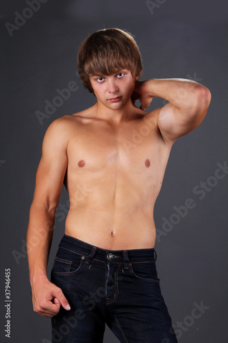 Healthy muscular young man. Isolated on dark background.