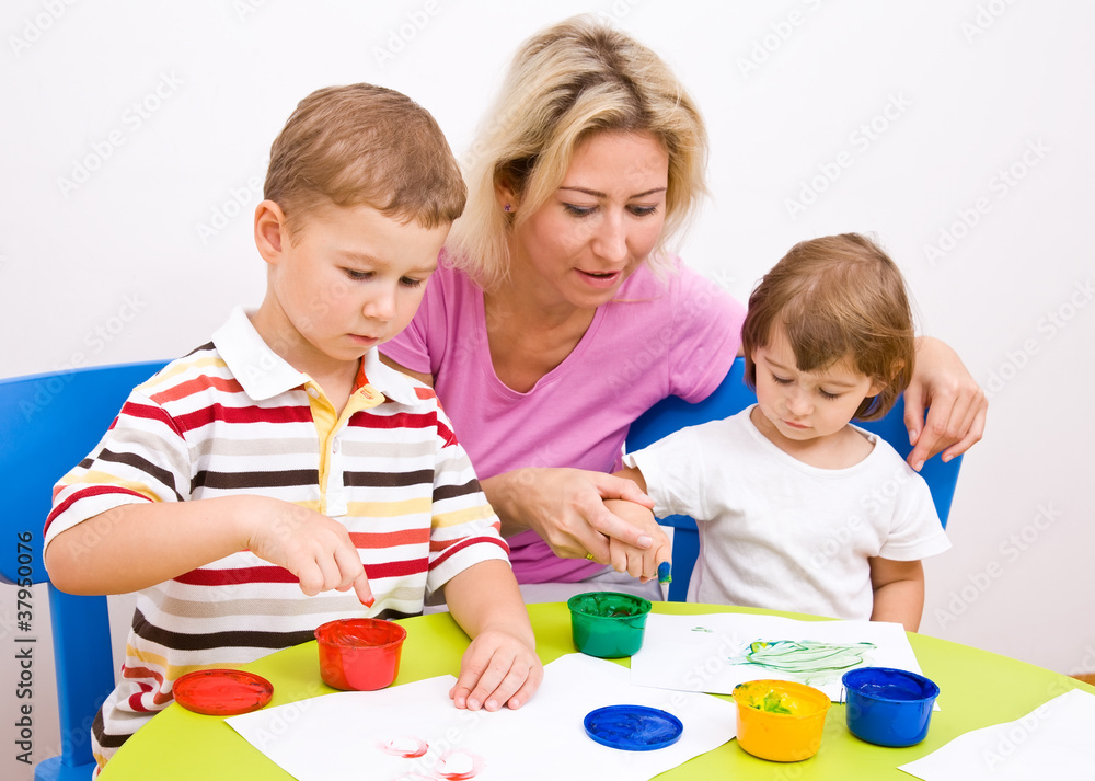 Boy and girl paint colors sitting at the table Boy and girl paint colors sitting at the table