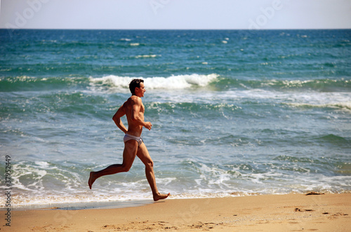 Young man running at the beach
