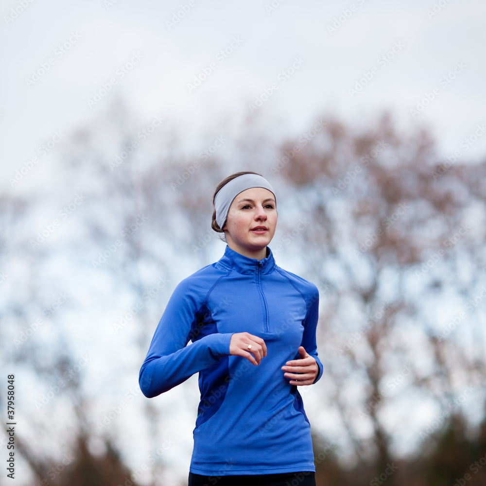 Fototapeta premium Portrait of a woman running against against blue sky