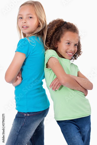 Portrait of smiling girls standing back to back
