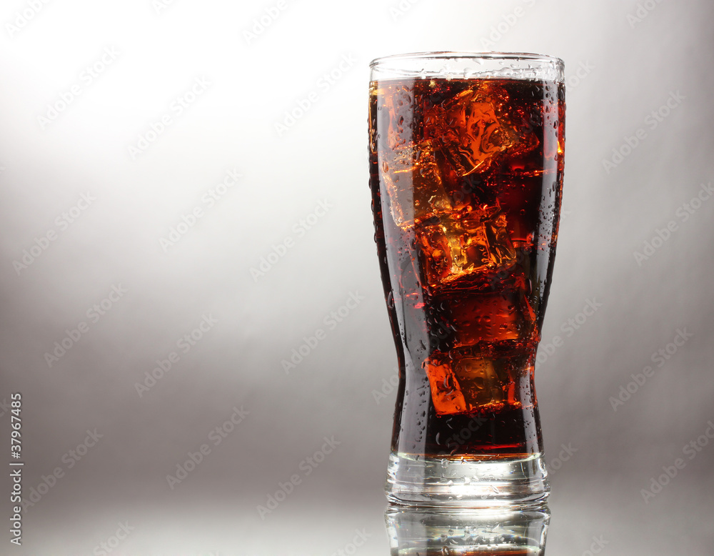 Glass of cola with ice on grey background Glass of cola with ice on grey background