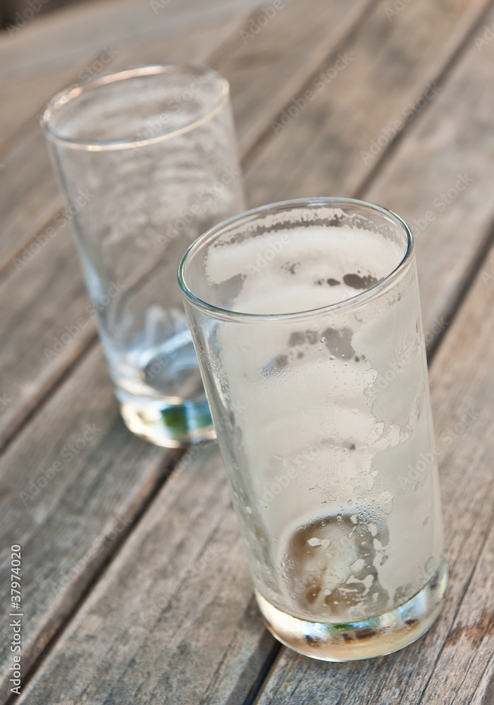Two empty beer glasses on a wooden table Two empty beer glasses on a wooden table