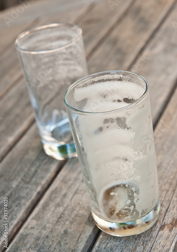 Two empty beer glasses on a wooden table