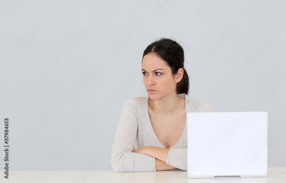 Jeune femme avec ordinateur portable sur fond gris Jeune femme avec ordinateur portable sur fond gris