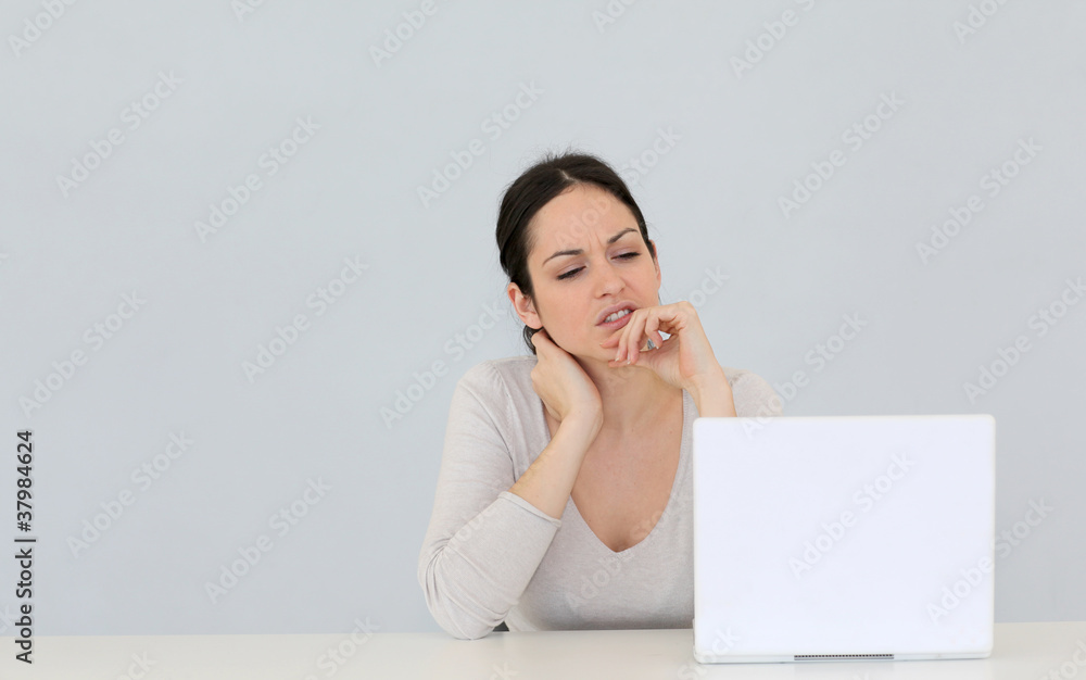 Jeune femme avec ordinateur portable sur fond gris Jeune femme avec ordinateur portable sur fond gris