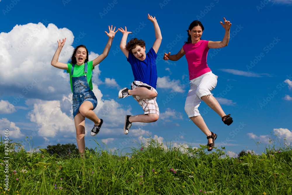 Active family - mother and kids jumping outdoor Active family - mother and kids jumping outdoor