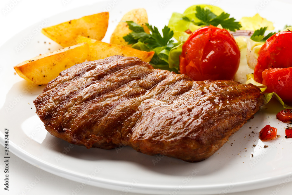 Grilled steak, baked potatoes and vegetable salad