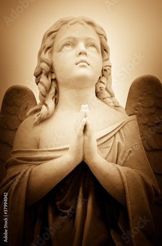 Beautiful vintage image of a praying angel in sepia shades