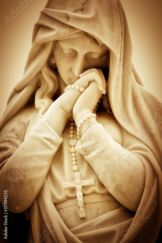 Vintage sepia image of a religious woman with a crucifix