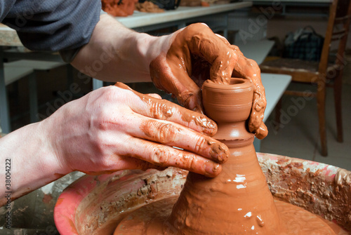 hands of a potter, creating an earthen jar on the circle