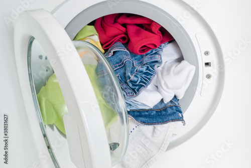 Фотография washing machine door full of colored clothes