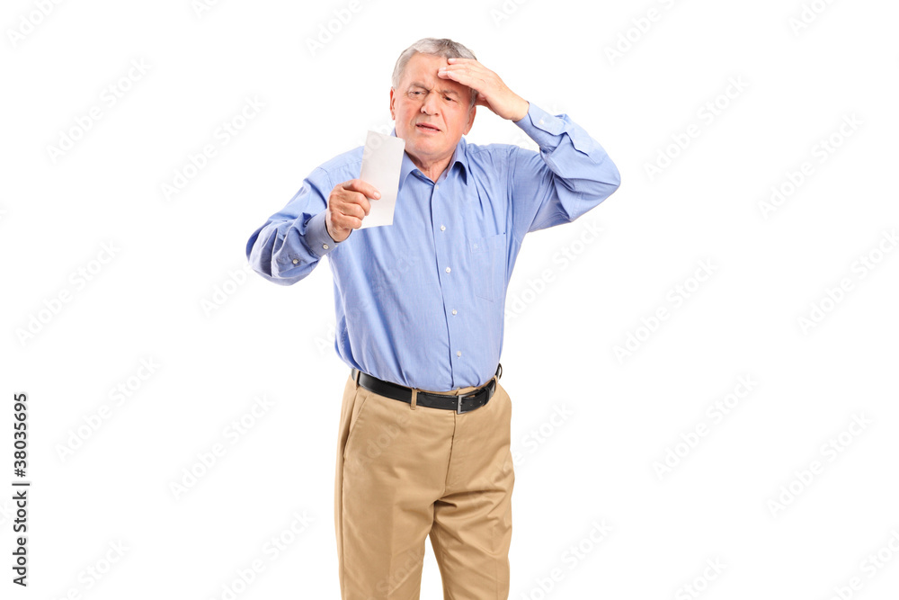 Fototapeta premium A surprised mature man looking at store receipt