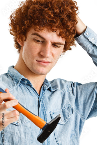 Canvas-taulu Portrait of a clumsy man trying to use an hammer
