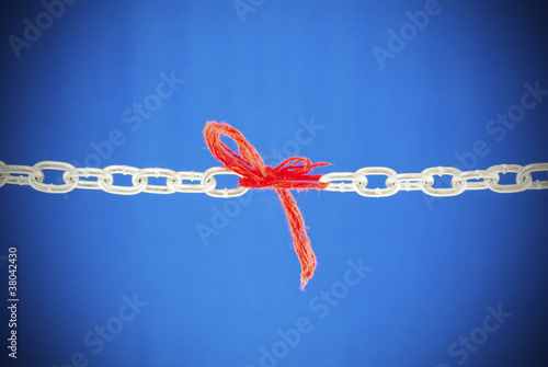Broken chain connected with red threads