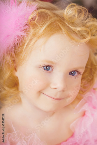 Girl in the nursery in pink dress