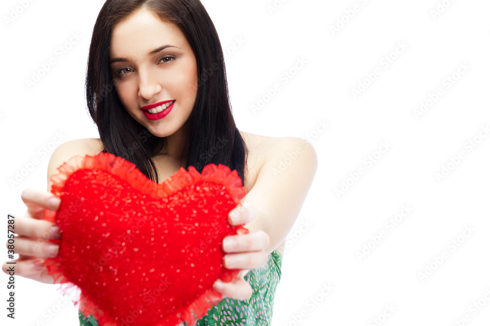 Cute young woman holds a heart symbol isolated on white backgrou Cute young woman holds a heart symbol isolated on white backgrou