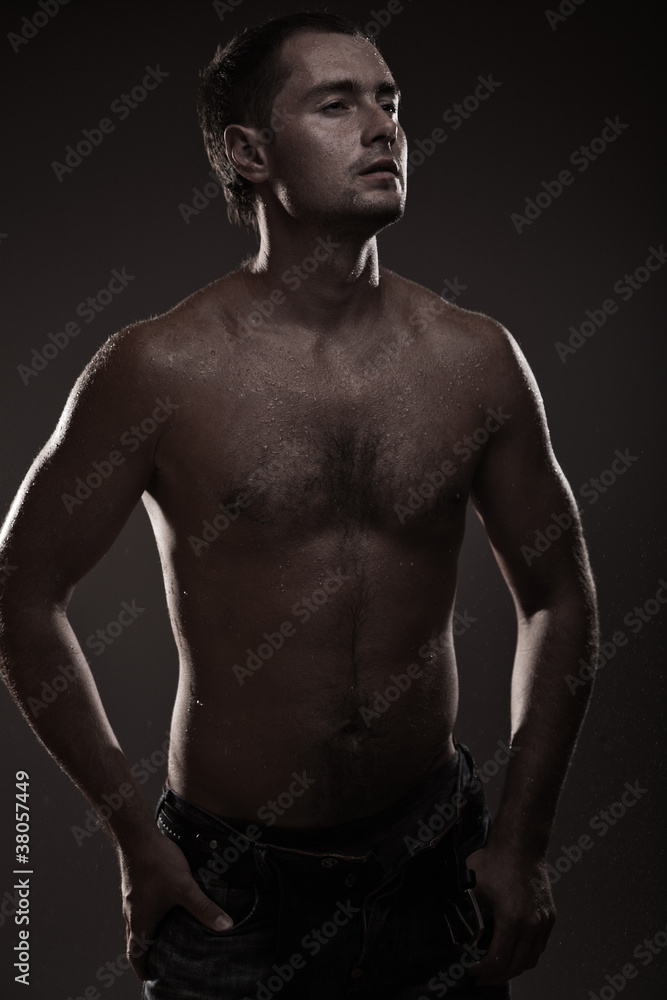 athletic young man with dewdrops on body