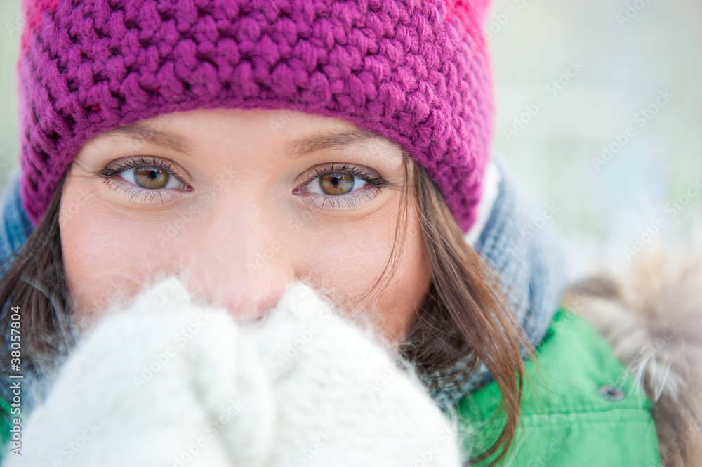 Winter woman in snow looking at camera outside on snowing cold w Winter woman in snow looking at camera outside on snowing cold w
