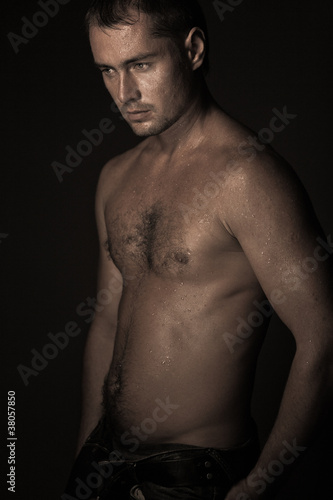 athletic young man with dewdrops on body
