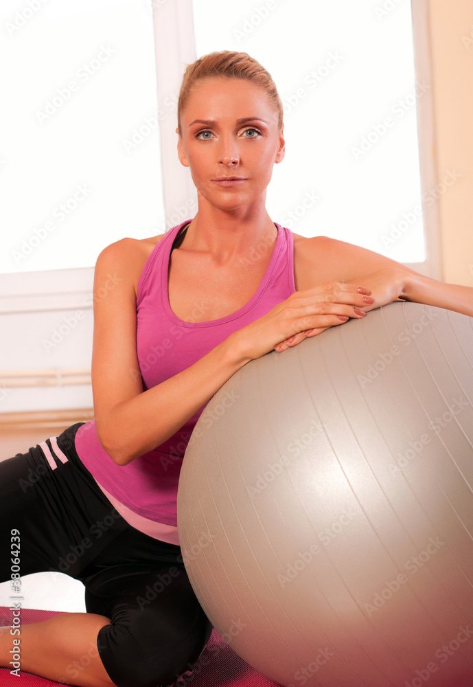 Young woman in sportswear, doing fitness exercise with fit ball. Young woman in sportswear, doing fitness exercise with fit ball.