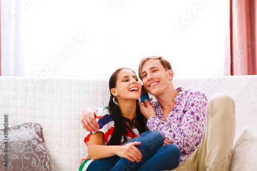 Smiling young couple speaking phone together