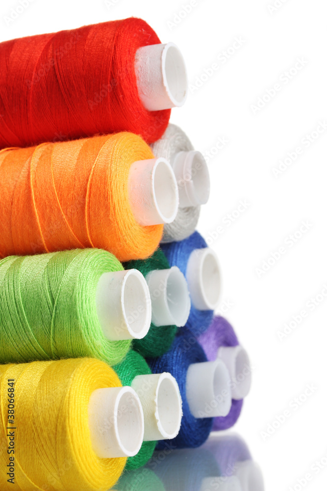 Pyramid of many-coloured bobbins of thread isolated on white Pyramid of many-coloured bobbins of thread isolated on white