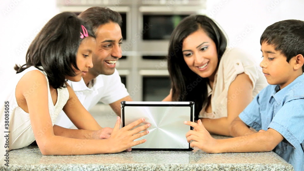 Young Ethnic Family with Wireless Tablet in Kitchen Young Ethnic Family with Wireless Tablet in Kitchen
