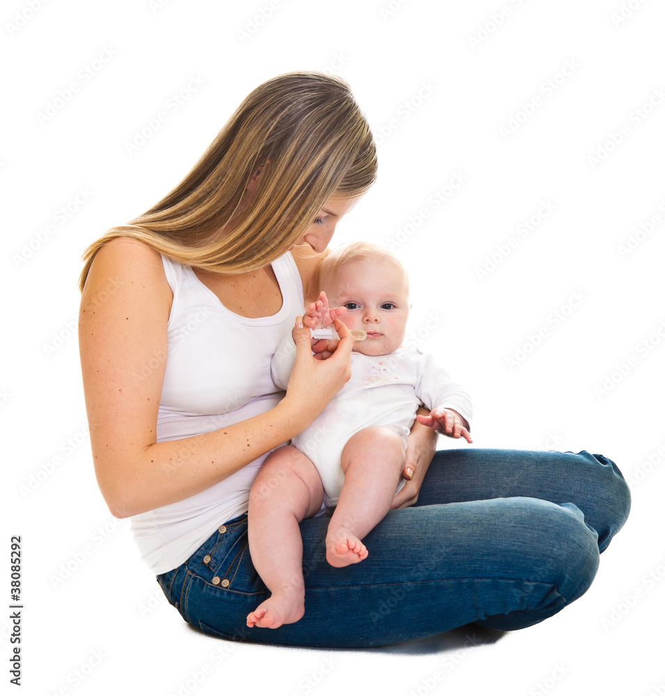 Mother giving vitamins to infant girl isolated on white