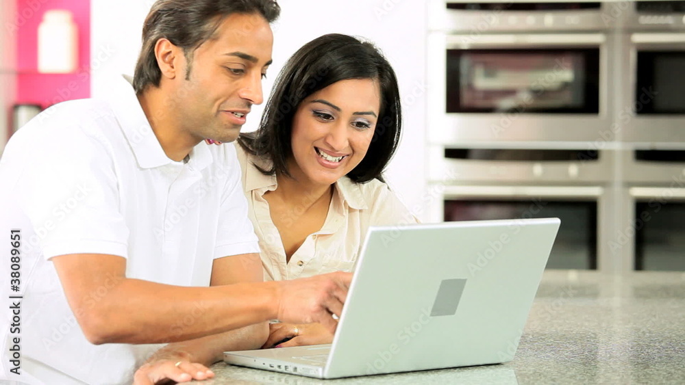 Young Ethnic Couple Online with Wireless Laptop Young Ethnic Couple Online with Wireless Laptop