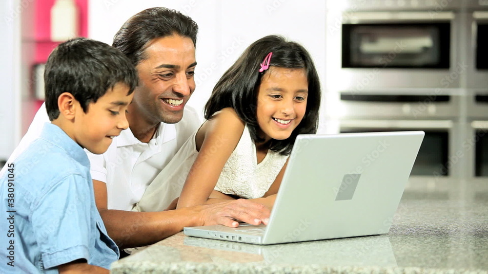 Young Ethnic Father & Children Using Laptop in Kitchen Young Ethnic Father & Children Using Laptop in Kitchen