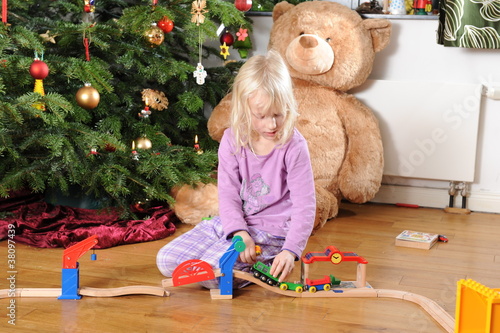 Kleines Mädchen spielt vorm Christbaum 2 photo