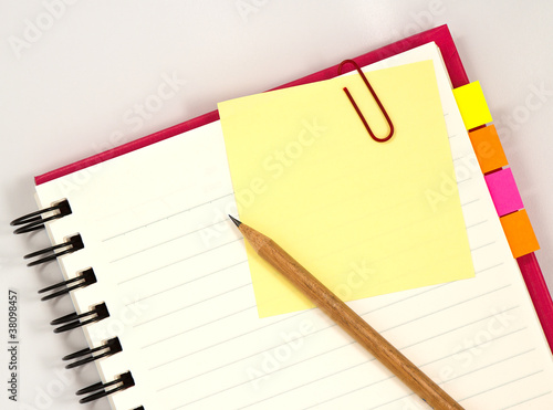 Red notebook with paper and pencil 