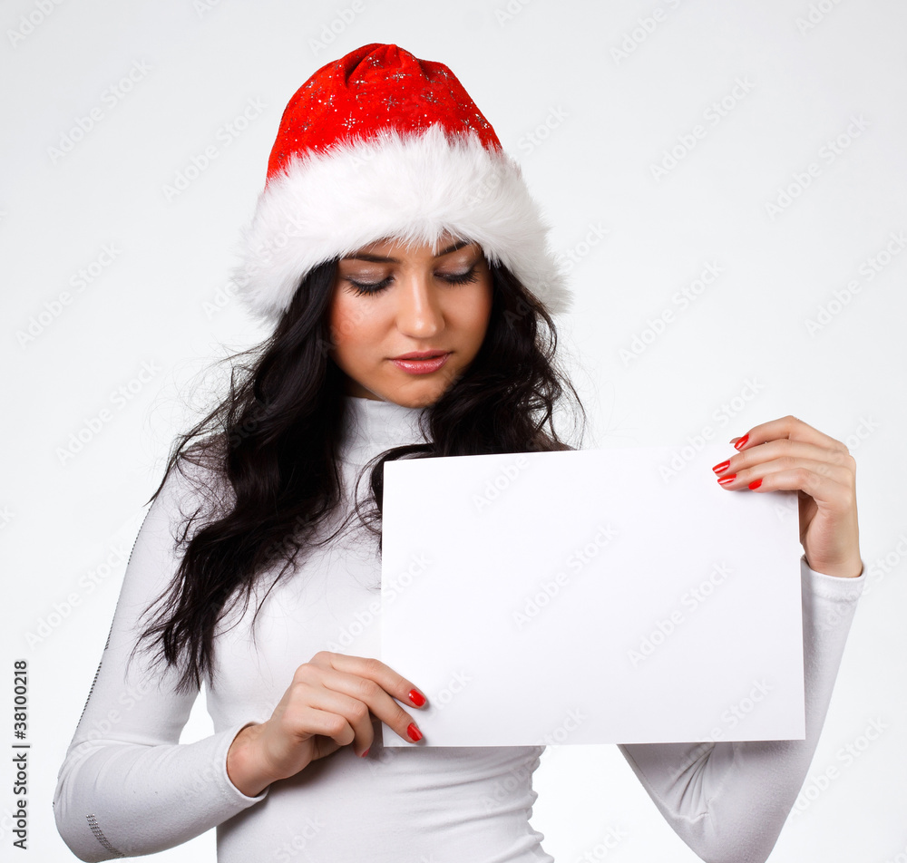 beautiful girl in a Santa Claus hat with a clean sheet of paper beautiful girl in a Santa Claus hat with a clean sheet of paper