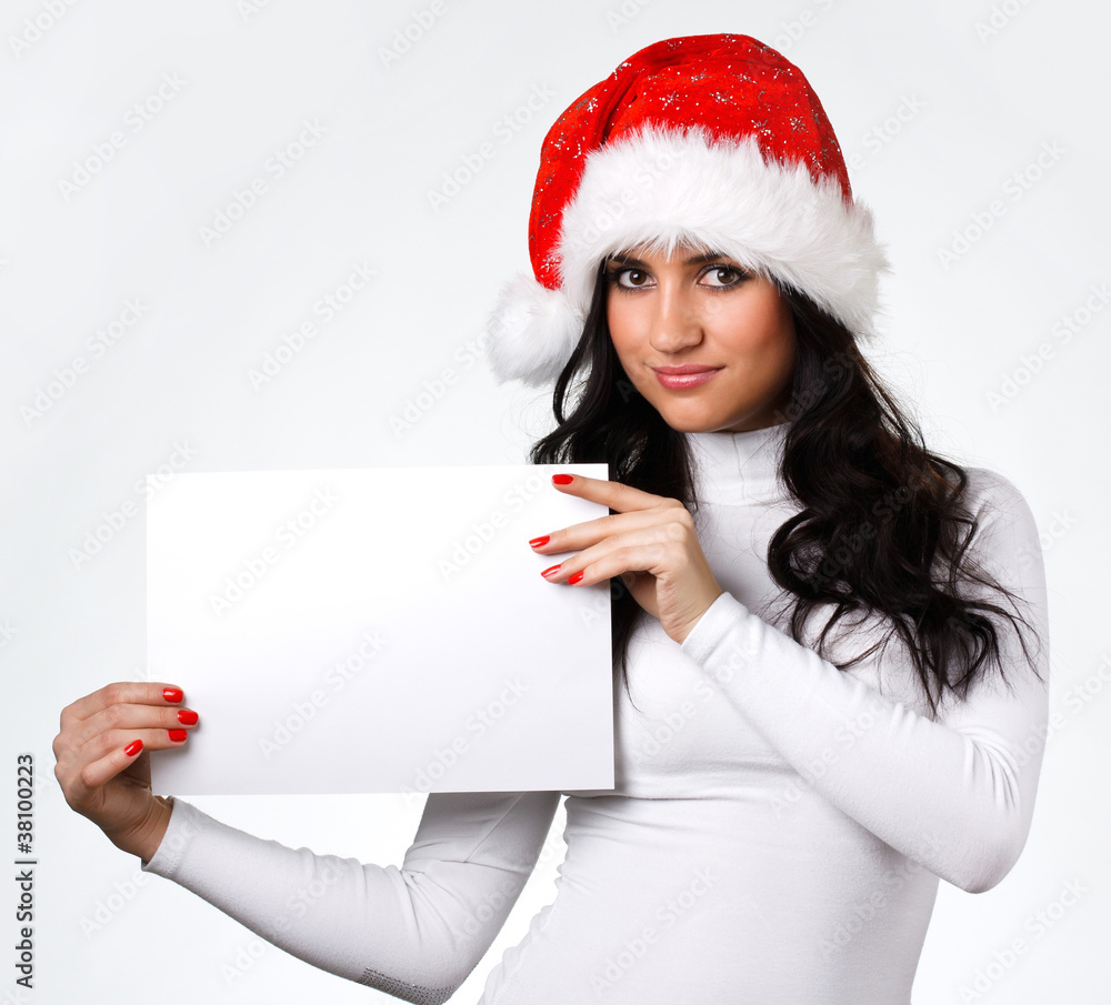 beautiful girl in a Santa Claus hat with a clean sheet of paper beautiful girl in a Santa Claus hat with a clean sheet of paper