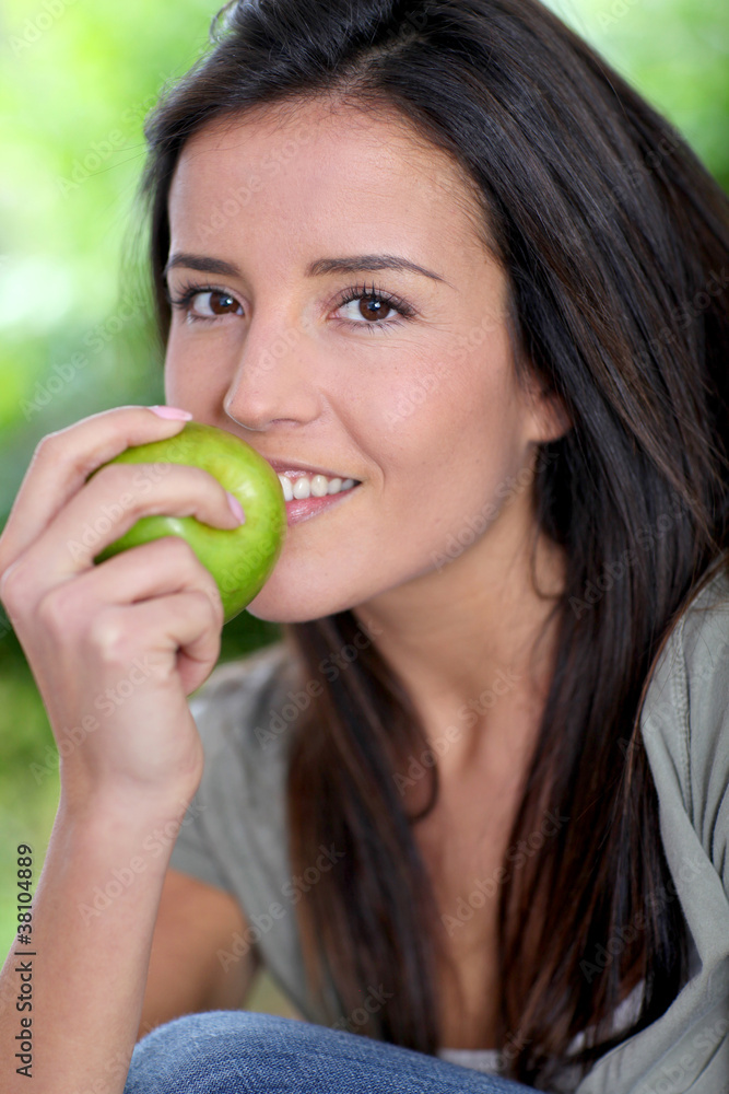 Portrait of woman sitting outside with apple Portrait of woman sitting outside with apple