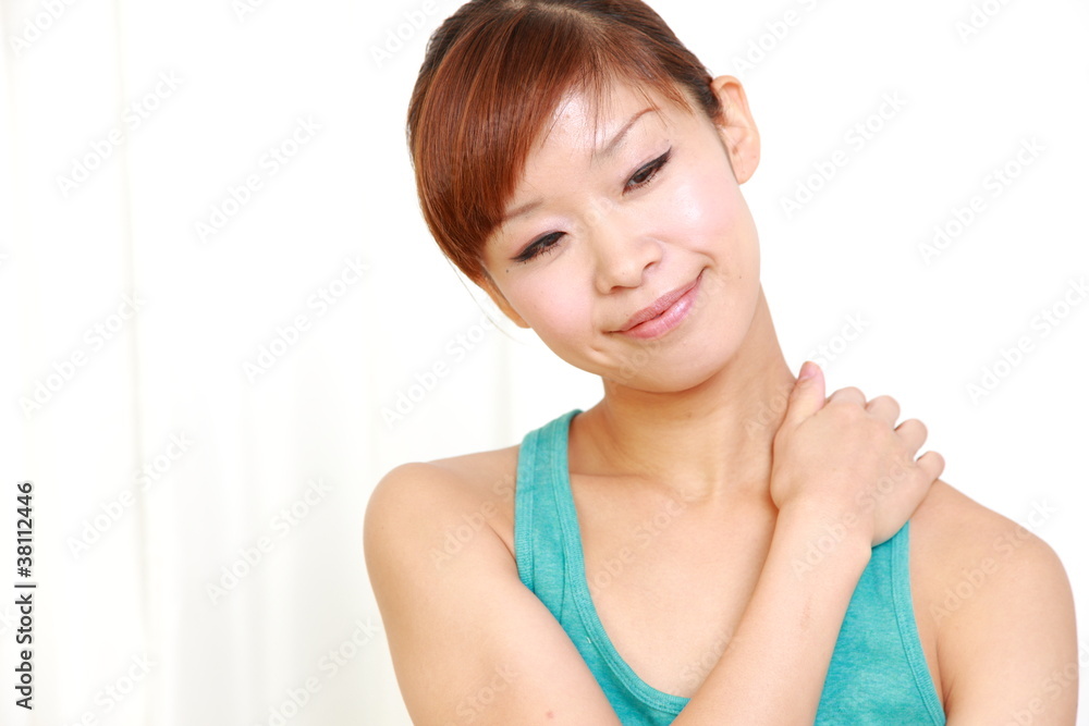 young japanese woman doing self shoulder massage young japanese woman doing self shoulder massage