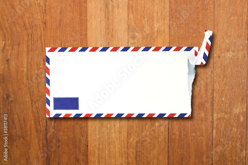 Envelope by air mail isolated on wood